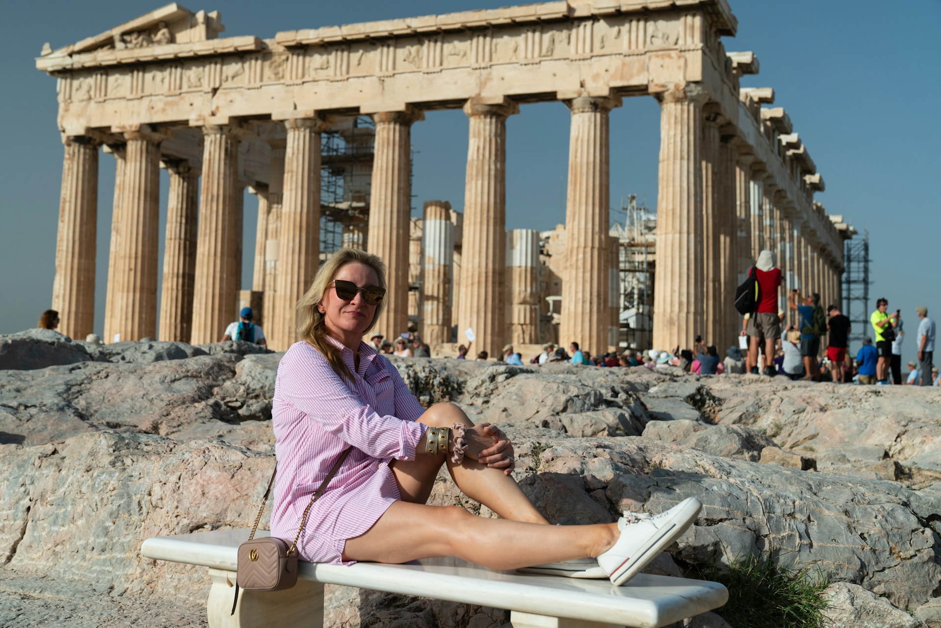 a woman sitting on a bench in front of a building