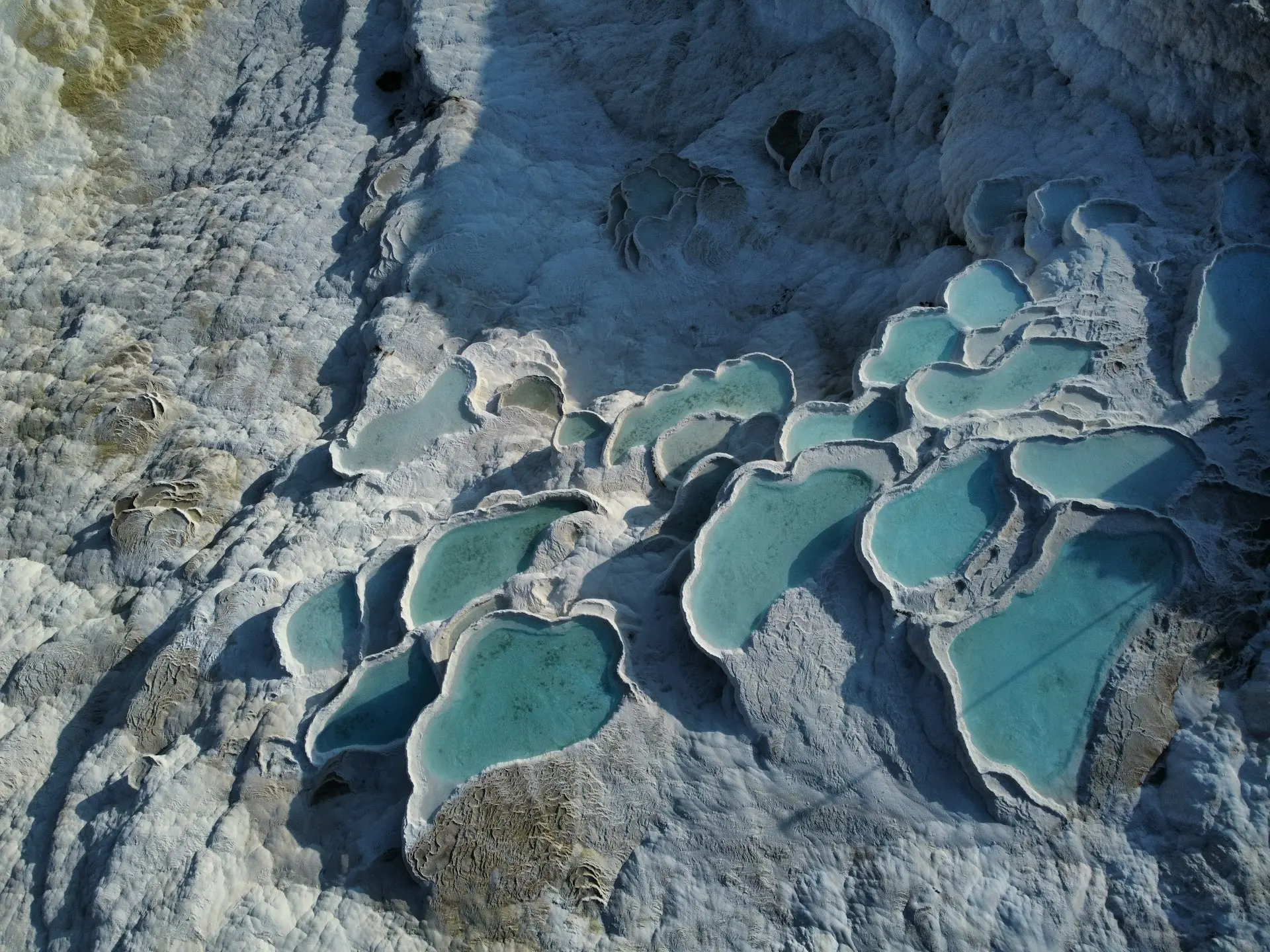 An aerial view of a rock formation with blue water